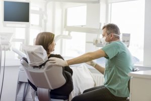 patient speaks with denturist in office chair